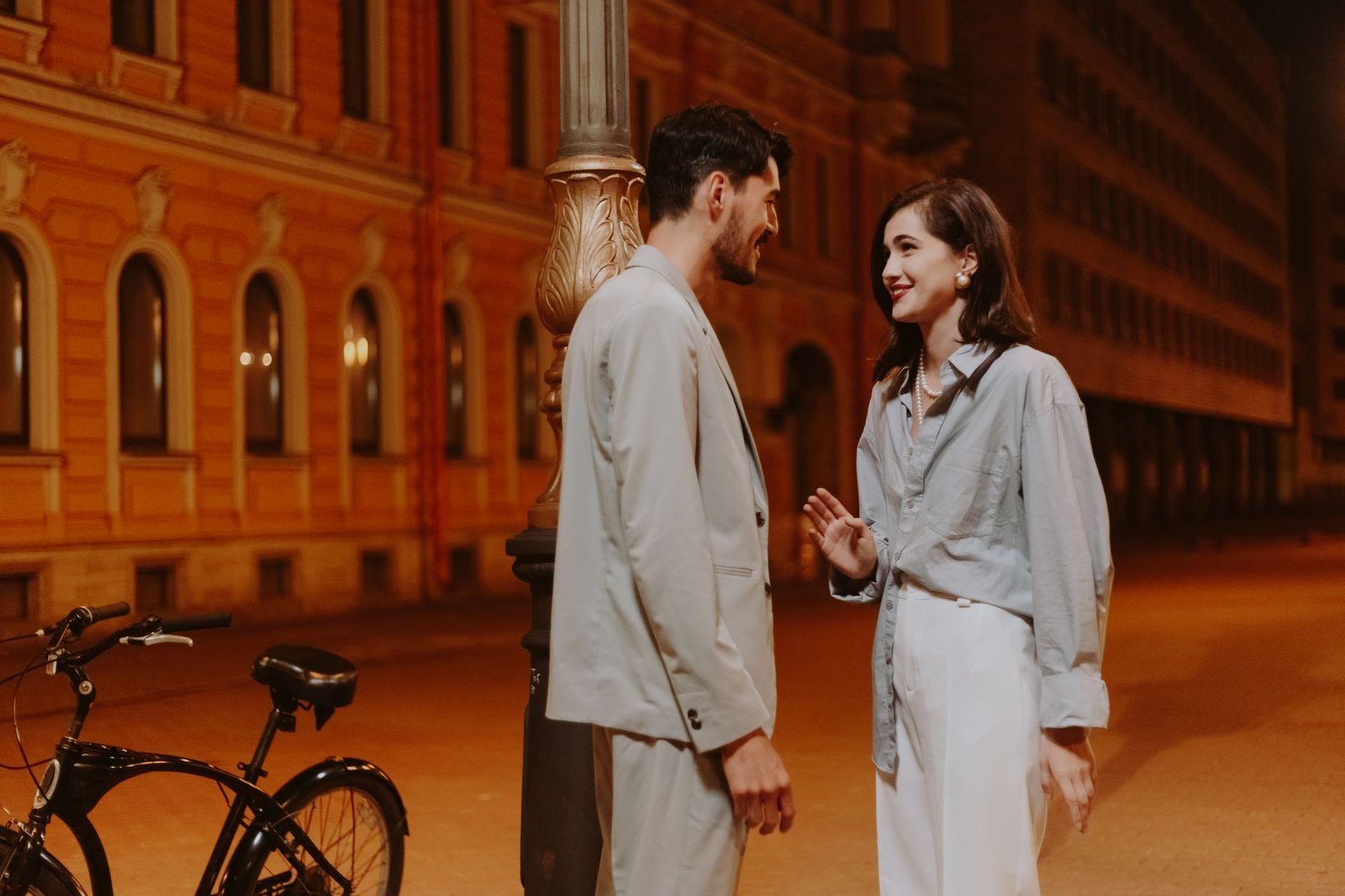 a couple standing beside the bicycle while having conversation