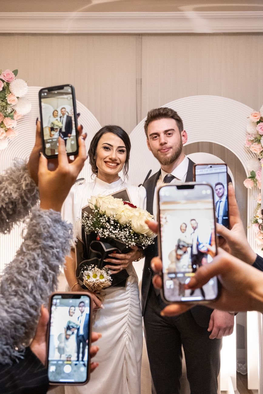 people taking pictures of newlyweds