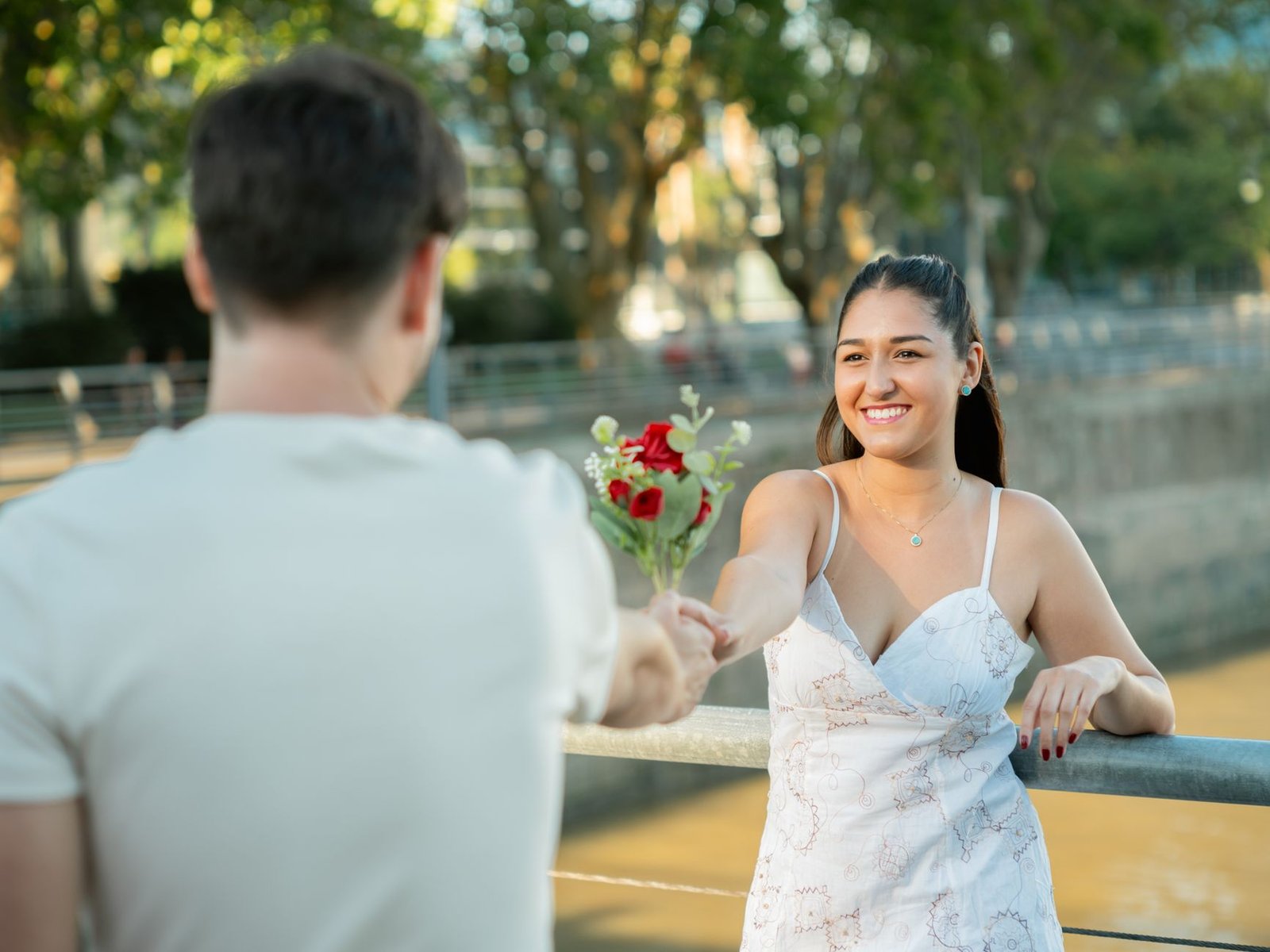 young couple on a date with roses by river