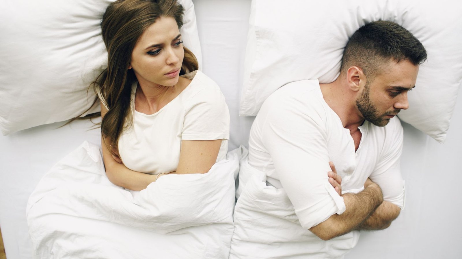 couple lying in bed facing away from each other