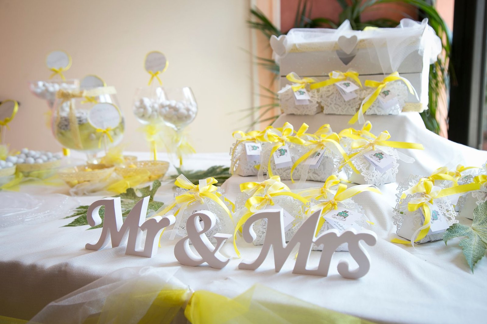 wedding souvenirs with yellow ribbons on a white table