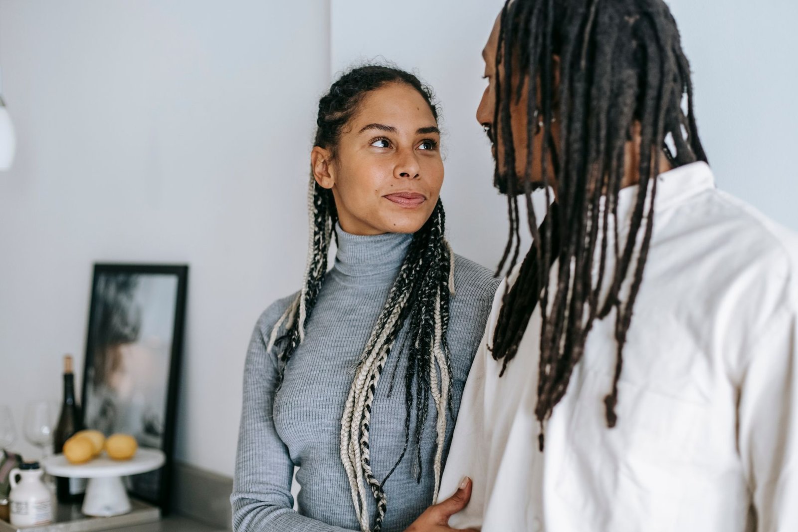 ethnic couple with braids gently looking at each other