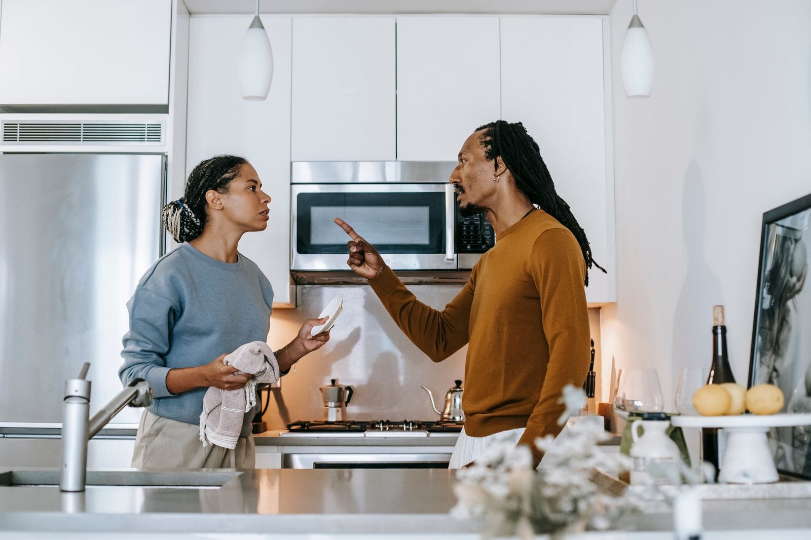 annoyed black man threatening girlfriend during conflict in kitchen