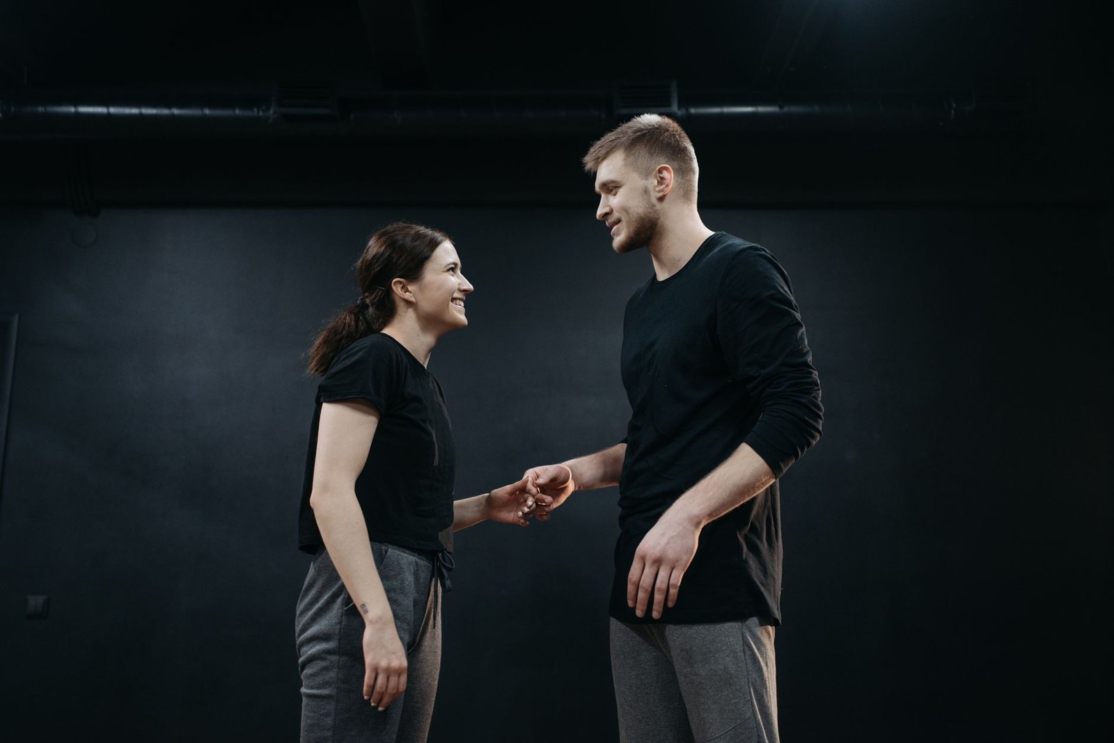 man and woman standing face to face with their hands close to each other