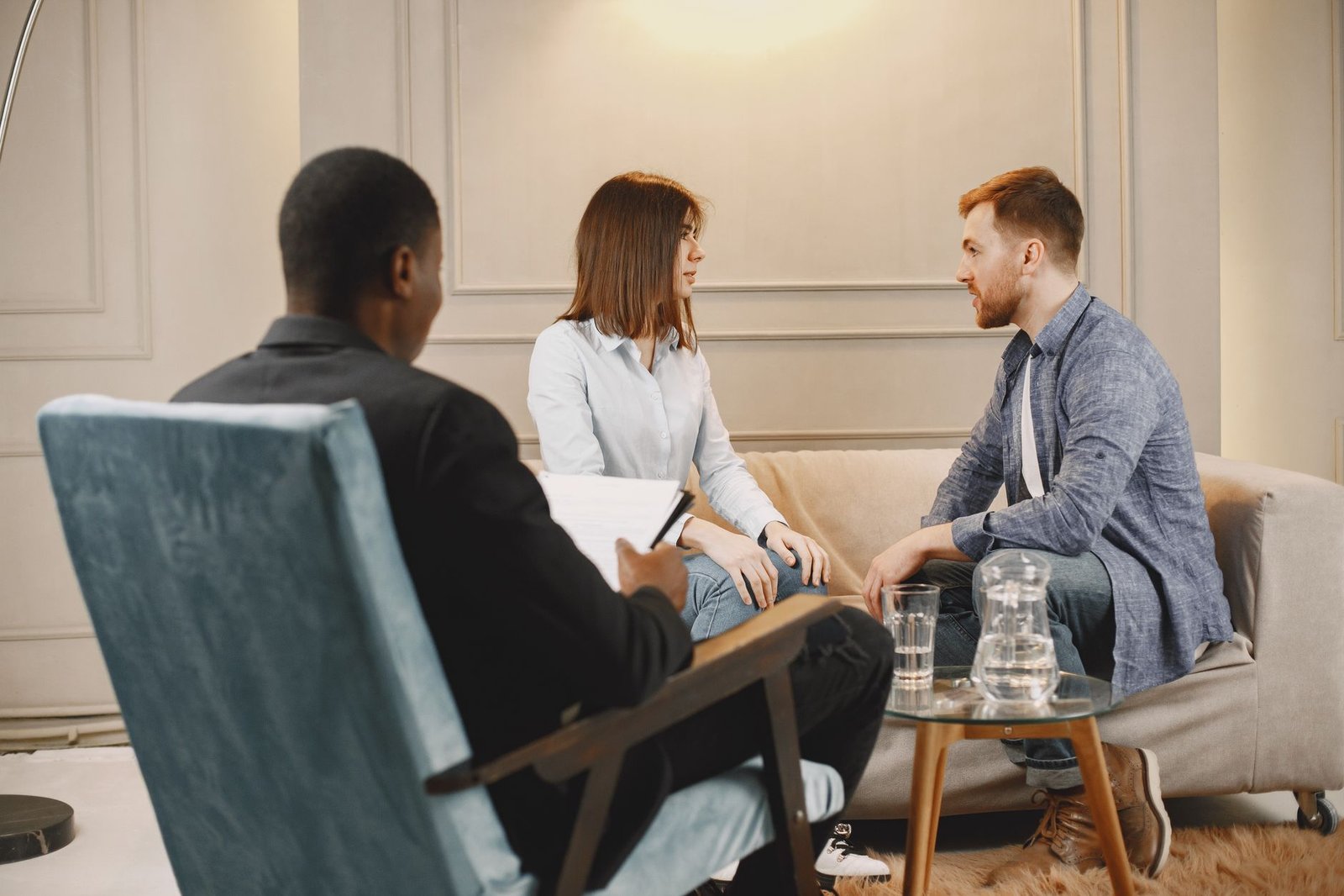 couple talking in front of a man in black suit