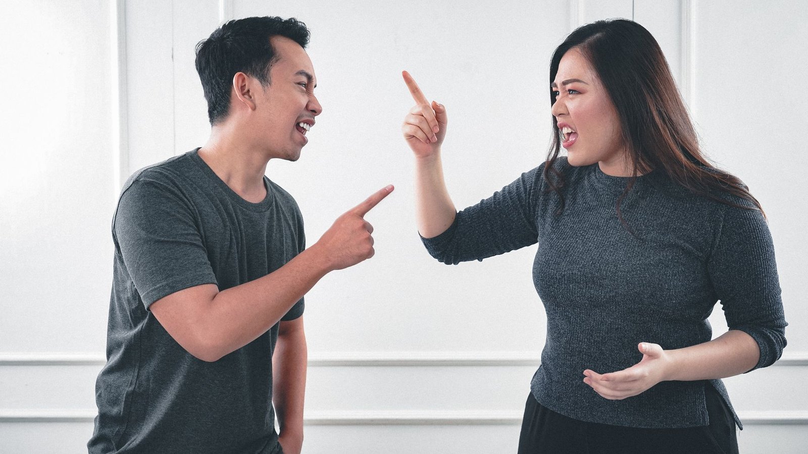 a man and woman arguing while pointing fingers