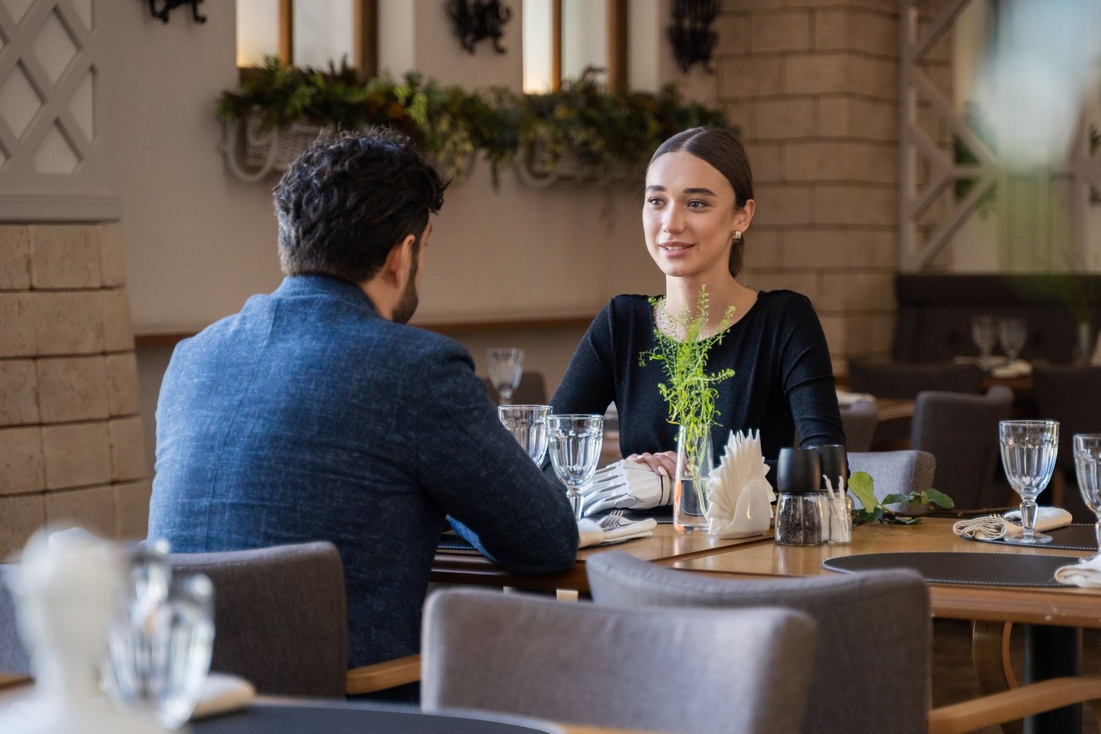 man and woman sitting in a restaurant on date