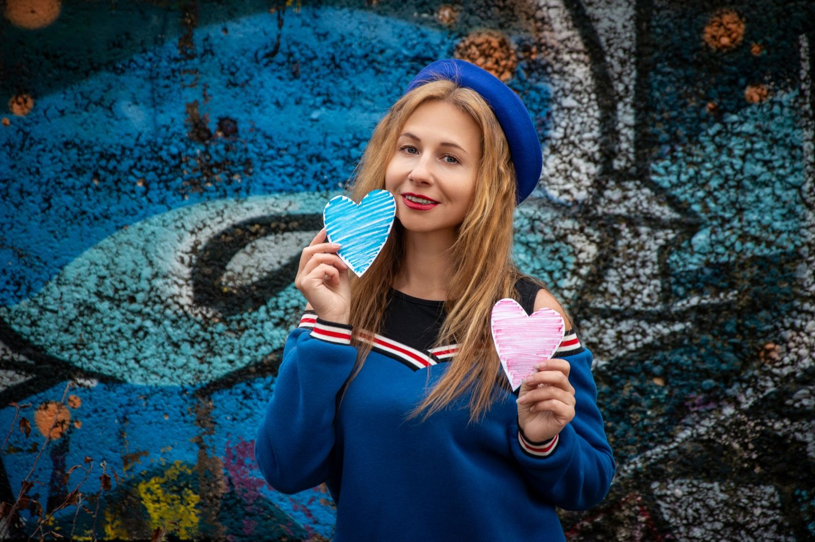 woman holding paper hearts in urban setting