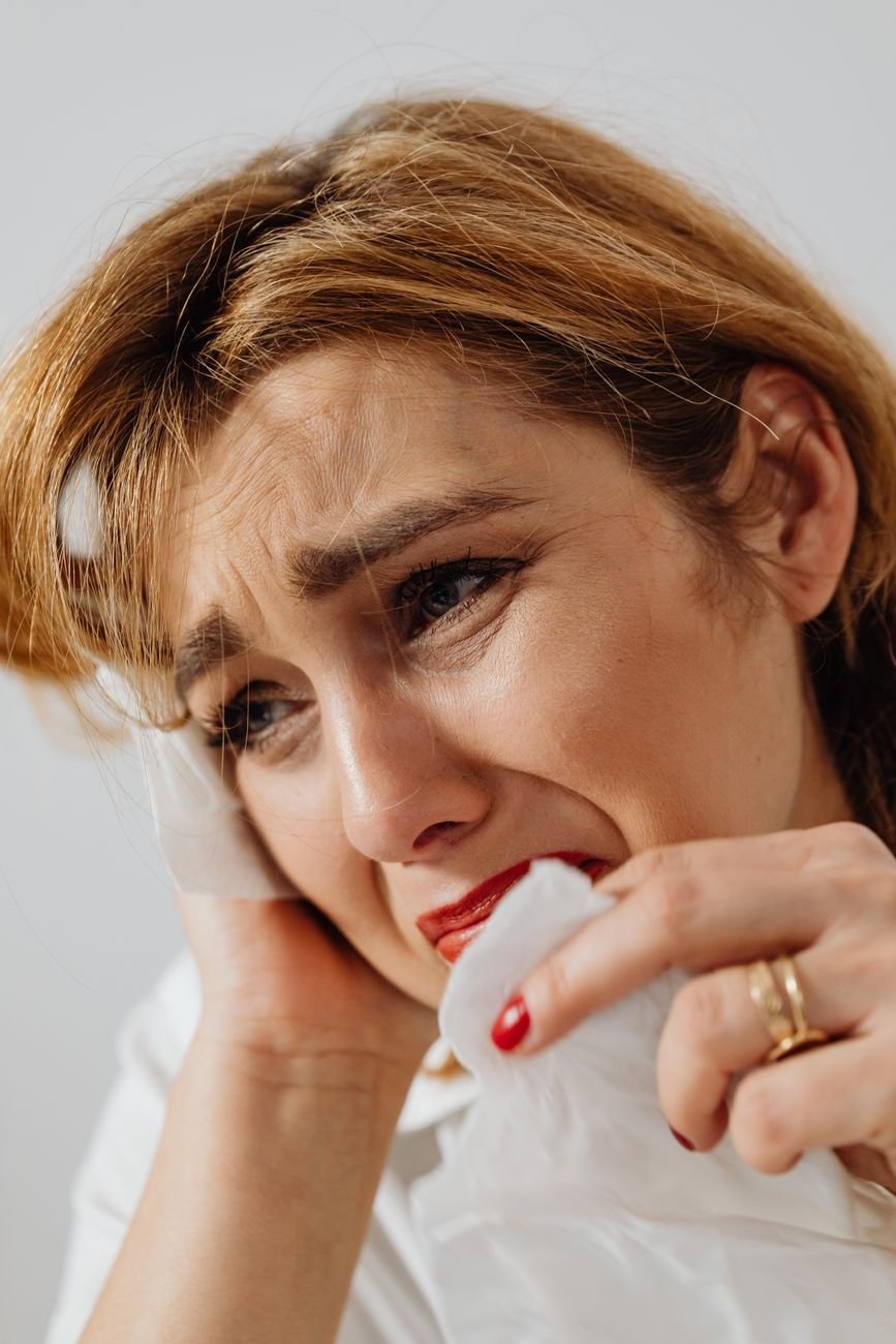 close up shot of a sad woman holding a tissue